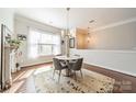 Cozy dining room with bright natural light, hardwood floors, and elegant chandelier fixture at 15133 Rocky Bluff Loop, Davidson, NC 28036