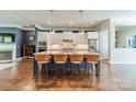 This is a kitchen with an island and seating, granite countertops and modern appliances in a spacious open floor plan at 15133 Rocky Bluff Loop, Davidson, NC 28036