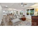 Open-concept living room with wood floors, a cozy couch, and lots of natural light at 207 Blythe Mill Rd, Waxhaw, NC 28173