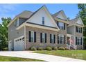 Stylish two-story home featuring a brick facade, grey siding, an attached garage, and well-maintained landscaping at 3011 Waxhaw Crossing Dr, Waxhaw, NC 28173