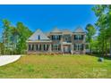Beautiful two-story brick home with manicured lawn, black shutters, and a welcoming front porch at 3011 Waxhaw Crossing Dr, Waxhaw, NC 28173