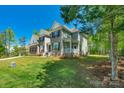 Charming two-story home featuring a side porch, lush lawn, and mature trees at 3011 Waxhaw Crossing Dr, Waxhaw, NC 28173