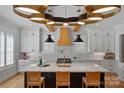 This kitchen features a large island, quartz countertops, pendant lighting and stainless steel appliances at 3228 E Ford Rd, Charlotte, NC 28205