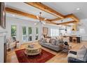 Open-concept living room with exposed wood beams, hardwood floors, and access to a patio, creating inviting spaces at 3228 E Ford Rd, Charlotte, NC 28205