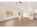 Bright, open-concept living room with wood-look flooring and a sliding glass door at 3330 Strong Box Ln, Gastonia, NC 28052