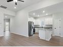Bright kitchen featuring white cabinets, stainless steel appliances, a granite island, and light wood flooring at 3435 Saddlebred Dr, Gastonia, NC 28052