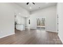 Open-concept living space showcasing light wood floors, a sliding glass door, and a view of the kitchen at 3435 Saddlebred Dr, Gastonia, NC 28052