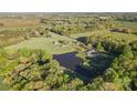 Scenic aerial view of estate, highlighting a large pond bordered by lush trees and green fields at 36984 B&C Carter Rd, New London, NC 28127