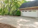 Detached brick garage with white doors and ample parking space on the large concrete driveway at 3815 Glen Haven Sw Dr, Concord, NC 28027