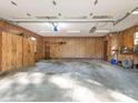 Spacious garage interior with paneled walls, overhead lighting, and ample storage and workspace at 3815 Glen Haven Sw Dr, Concord, NC 28027