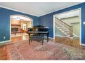 Inviting formal living room featuring hardwood floors, a decorative rug, and access to the staircase at 3815 Glen Haven Sw Dr, Concord, NC 28027