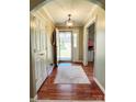 Inviting entryway with hardwood floors, neutral walls, stylish light fixture and seamless transition to the living spaces at 5505 Weavers Row, Gastonia, NC 28056