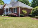 A classic brick house featuring well-maintained landscaping, adding to the curb appeal and highlighting the home's architecture at 5505 Weavers Row, Gastonia, NC 28056