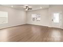 Bright and airy living room featuring luxury vinyl flooring, ceiling fan, and natural light at 7011 Jerimoth Dr, Charlotte, NC 28215