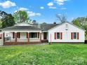 Traditional home exterior features a brick porch and red accents, offering a classic appeal at 7410 Middlebury Pl, Charlotte, NC 28212