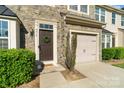Charming townhome with stone facade, manicured landscaping, and attached one-car garage at 9618 Springholm Dr, Charlotte, NC 28278