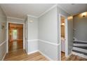 Inviting hallway with beautiful wood floors, crown molding, and access to bath and stairs at 10805 Winterbourne Ct, Charlotte, NC 28277