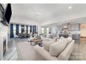 Open-concept living room features modern decor, hardwood floors, fireplace and access to the kitchen at 109 Crossvine Dr, Mooresville, NC 28117