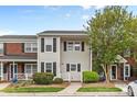 Charming two-story townhome with light siding, dark shutters and green landscaping at 10942 Winterbourne Ct, Charlotte, NC 28277