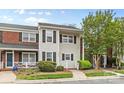 Charming two-story townhome with light siding, dark shutters and green landscaping at 10942 Winterbourne Ct, Charlotte, NC 28277