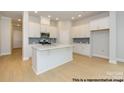 Modern, all-white kitchen with a large center island, stainless steel appliances, and light hardwood floors at 1107 Meander Ln, Waxhaw, NC 28173