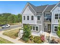 An aerial view of a gray two-story townhome featuring a landscaped front yard with white railing and healthy lawn at 134 Berkeley Ave, Mooresville, NC 28117