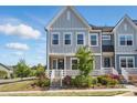 Charming two-story townhome with a landscaped front yard and inviting entrance with white railing at 134 Berkeley Ave, Mooresville, NC 28117