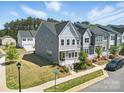 Two-story gray townhome with a landscaped front yard, sidewalk, and well-maintained lawn on a sunny day at 134 Berkeley Ave, Mooresville, NC 28117
