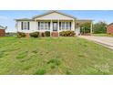 Charming one-story home featuring a covered porch, attached carport, and a well-maintained front lawn at 1504 Andicot Ln, Shelby, NC 28152