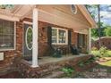 Inviting front porch with seating area, framed by brick columns and complemented by blossoming landscaping at 1565 Oakridge Dr, Salisbury, NC 28146