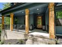 Inviting front porch with wood columns and dark blue siding offering an appealing entry at 16518 Here At Last Ln, Charlotte, NC 28278