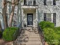 Inviting front entrance with concrete steps, black railing and well-manicured bushes at 216 Wakefield Dr # B, Charlotte, NC 28209