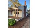 Cozy single-story home featuring a covered porch and an adjacent brick chimney at 240 North Ave, Troutman, NC 28166