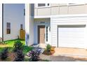 Close-up of the front door and garage of a new home with neatly landscaped yard at 2505 Elon St, Charlotte, NC 28208