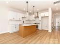 Bright kitchen features white cabinets, an island, stainless appliances, and hardwood floors at 2505 Elon St, Charlotte, NC 28208