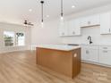 Bright kitchen features white cabinets, an island, stainless appliances, and hardwood floors at 2505 Elon St, Charlotte, NC 28208