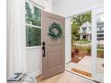 Open front door view showing bright interior, welcome mat, and exterior landscaping at 2507 Elon St, Charlotte, NC 28208