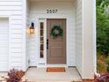 Inviting front entrance with a modern brown door, decorative wreath, and stylish exterior lighting at 2507 Elon St, Charlotte, NC 28208