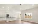 Bright open kitchen with white cabinetry, modern appliances, a breakfast bar, and scenic view windows at 3338 Strong Box Ln, Gastonia, NC 28052