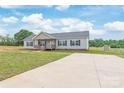 Well-manicured lawn and extended drive complement the pleasant gray home at 3648 Plainfield Dr, Shelby, NC 28150