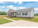 Inviting gray home featuring a cozy covered porch and manicured lawn at 3648 Plainfield Dr, Shelby, NC 28150