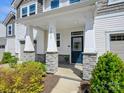 Welcoming front entrance with stone pillars and covered porch, showcasing the home's inviting facade at 3813 Amalia Pl, Indian Land, SC 29707