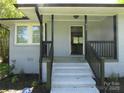 Inviting front porch with white brick stairs leading to a gray painted brick home with black accents at 412 E Broad St, Salisbury, NC 28144