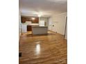 Open living space with laminate wood floors and a kitchen area in the background at 415 S Broad St, Gastonia, NC 28052