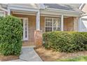 Inviting front porch with brick columns and manicured green bushes at 4418 Coventry Row Ct, Charlotte, NC 28270