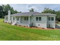Beautiful white brick home featuring well-manicured landscaping and a covered front porch at 4979 Plateau Rd, Vale, NC 28168