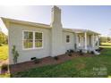 This home's exterior boasts a well-maintained brick facade, landscaping, and a cozy covered front porch at 4979 Plateau Rd, Vale, NC 28168