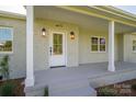 Close up of the front porch with stylish exterior lighting and a classic white front door at 4979 Plateau Rd, Vale, NC 28168