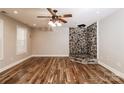 Spacious living room boasts unique rock fireplace, wood floors and ample natural light at 4989 Post Oak Ln, Rock Hill, SC 29732