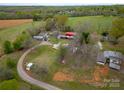 Aerial view of the property showing the home, outbuildings, fields, and surrounding countryside at 589 Lippard Farm Rd, Statesville, NC 28625